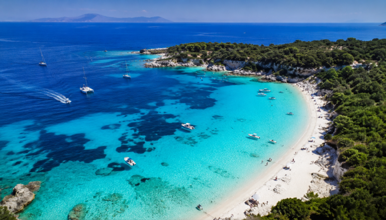 Drónfotó Antipaxos türkizkék vizéről és hófehér homokos strandjáról Görögországban.
